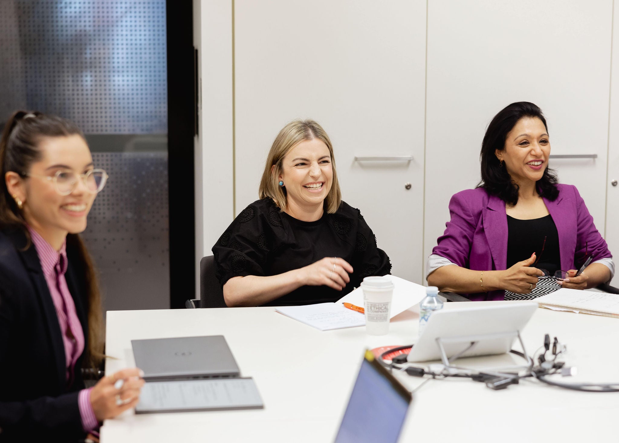 Photo of three people sitting in meeting room