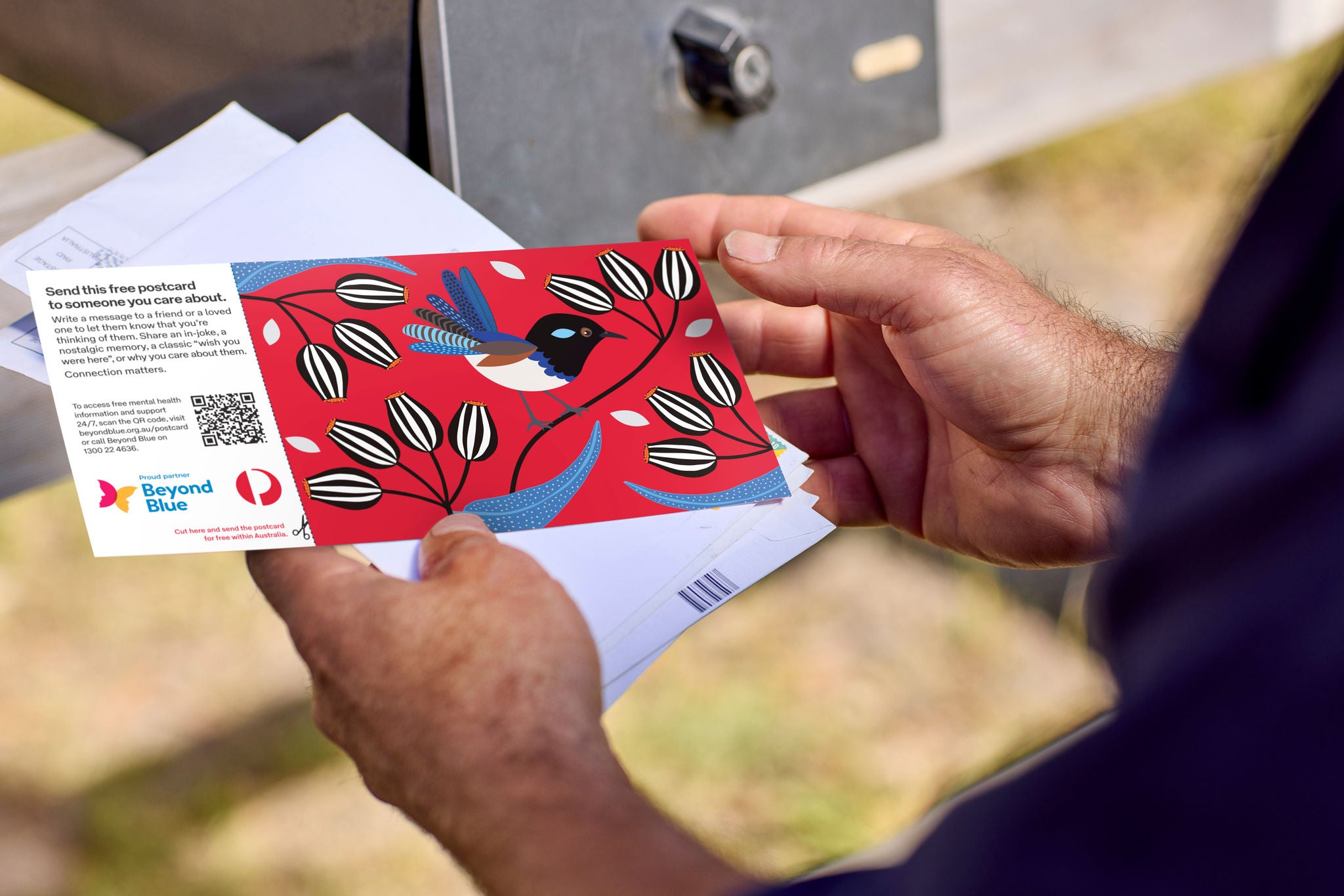 A person holding a Beyond Blue postcard