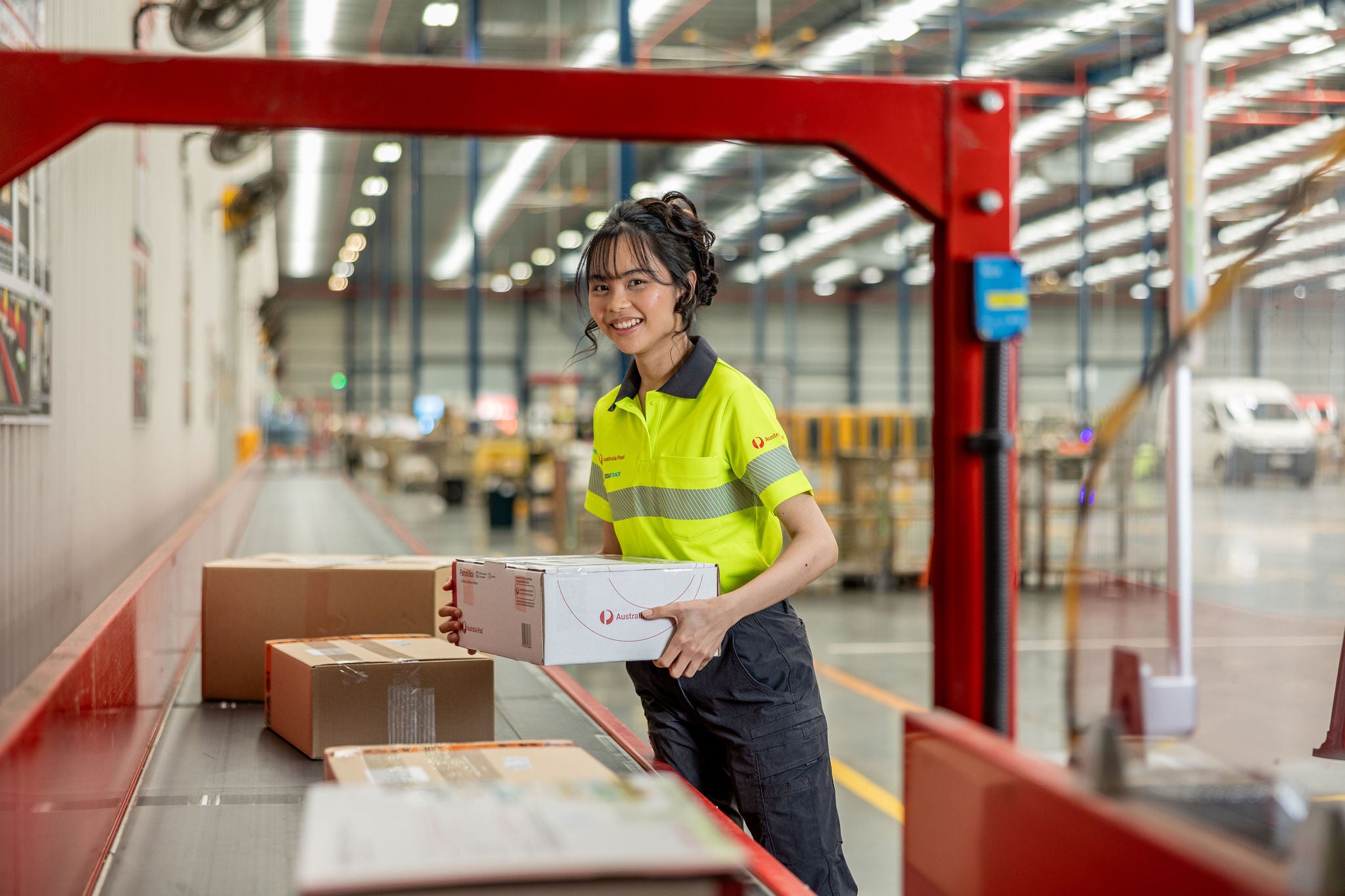 postie-warehouse-worker-female-woman-smiling-parcel