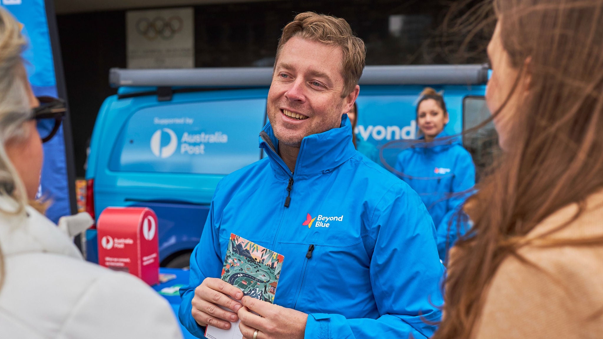 photo-man-from-beyond-blue-speaking-to-community-members-in-front-of-van