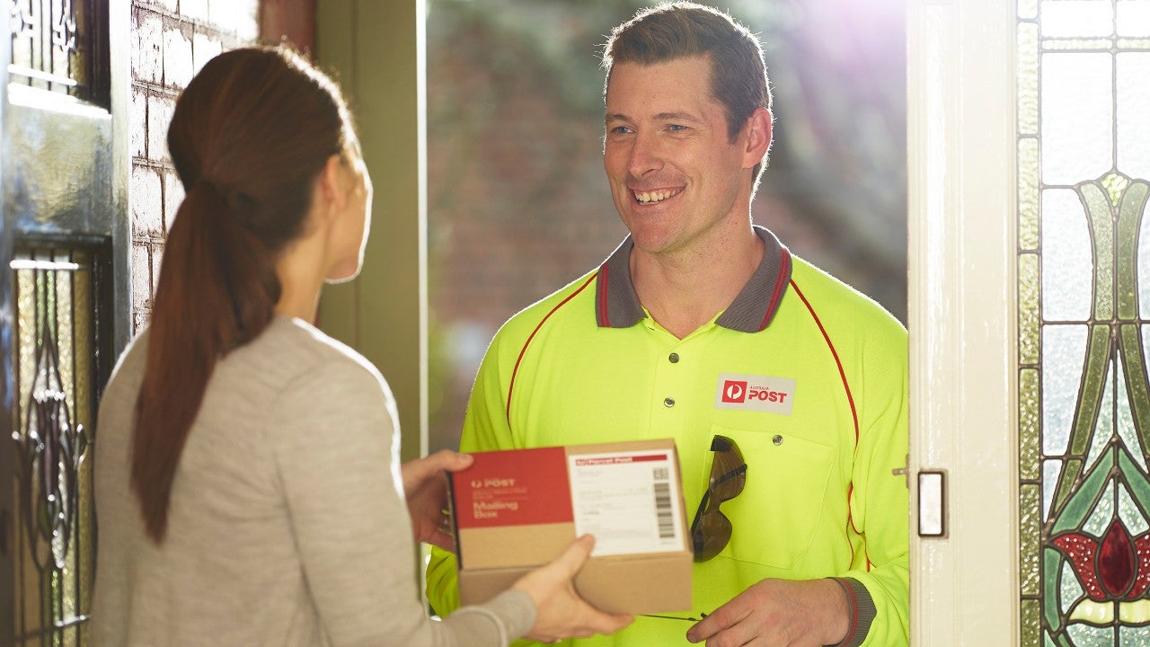 Post man delivering a parcel, residential.