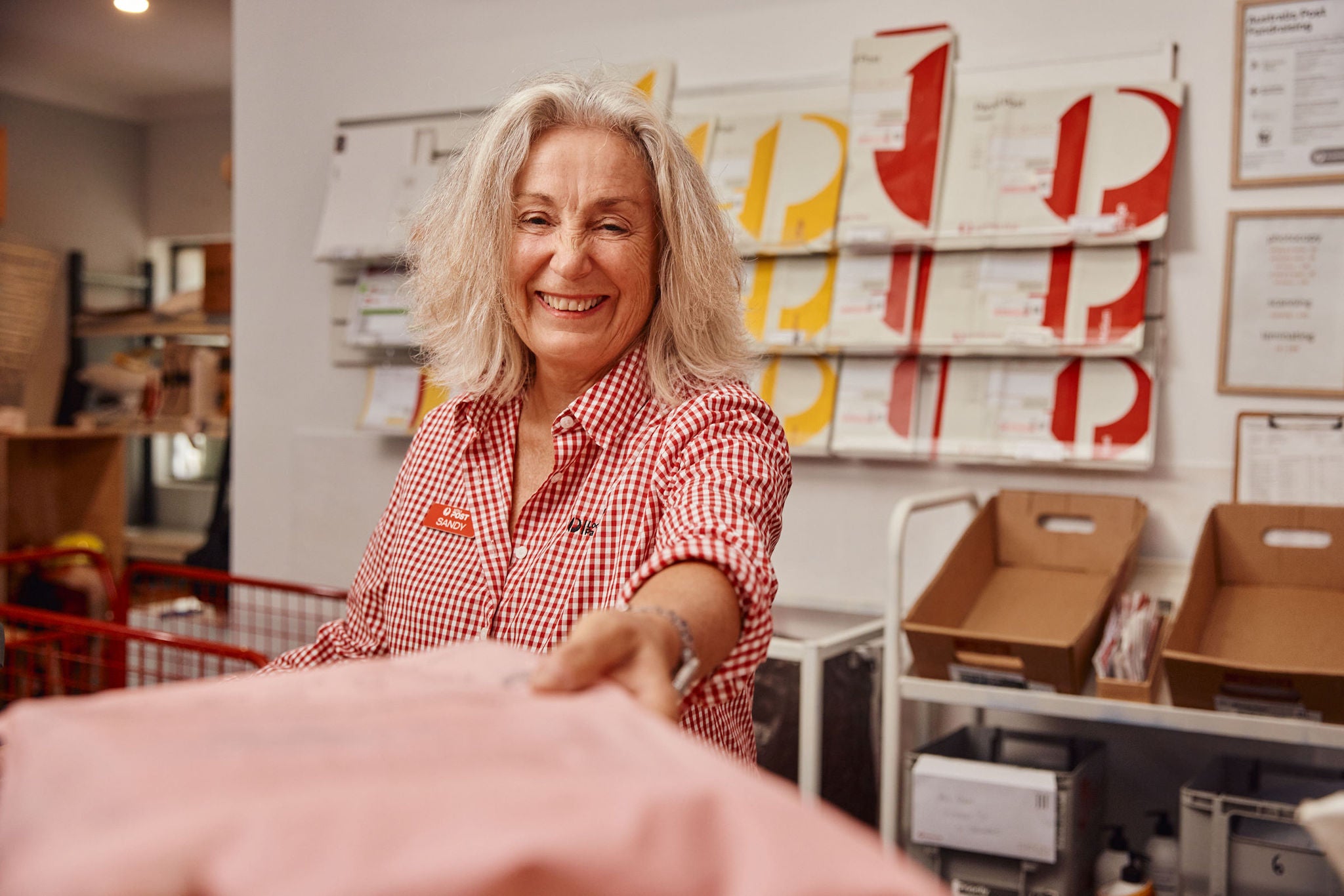 Auspost employee accepting a parcel from a customerin Post office