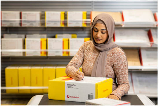 Retail worker standing near express post products in a post office