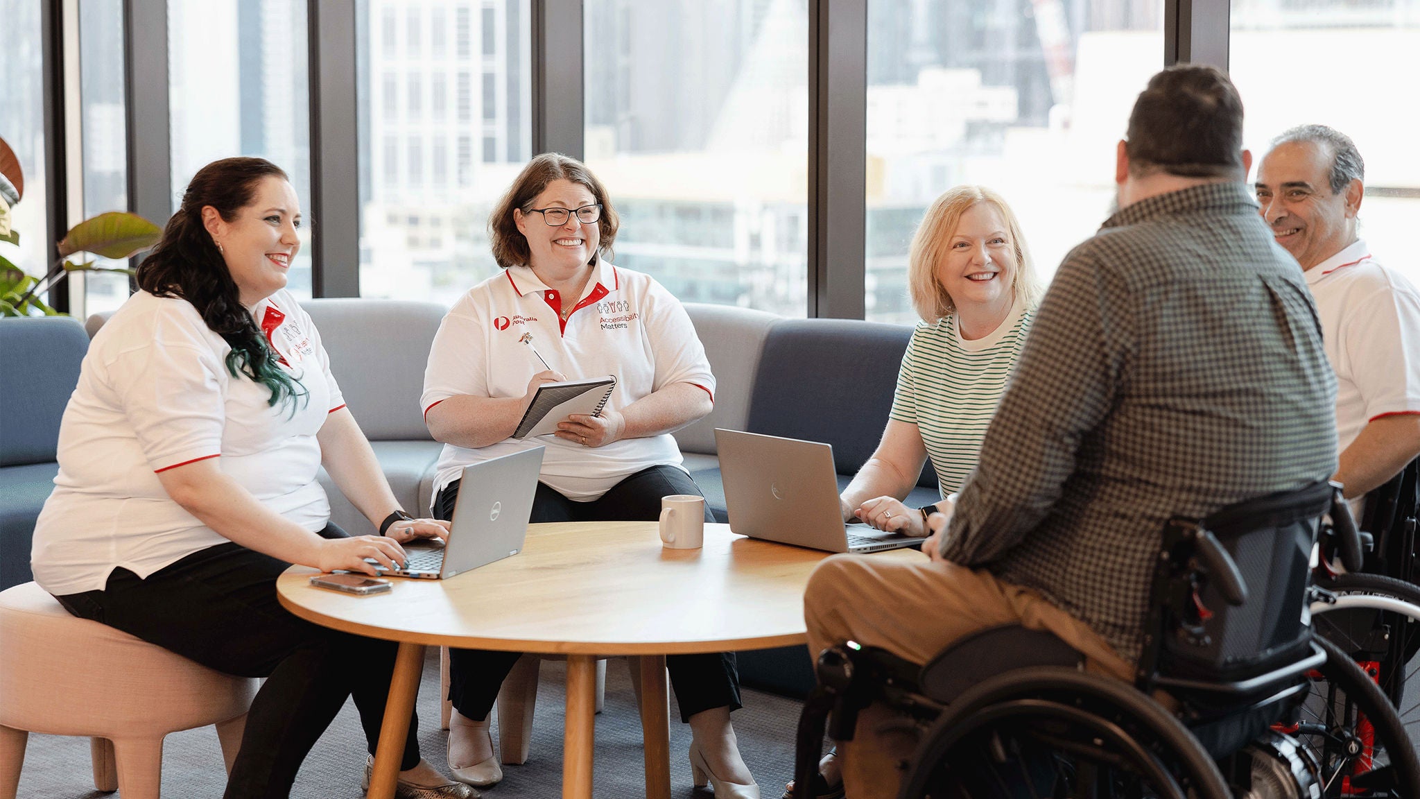 photo-three-women-and-two-men-sitting-around-table-talking