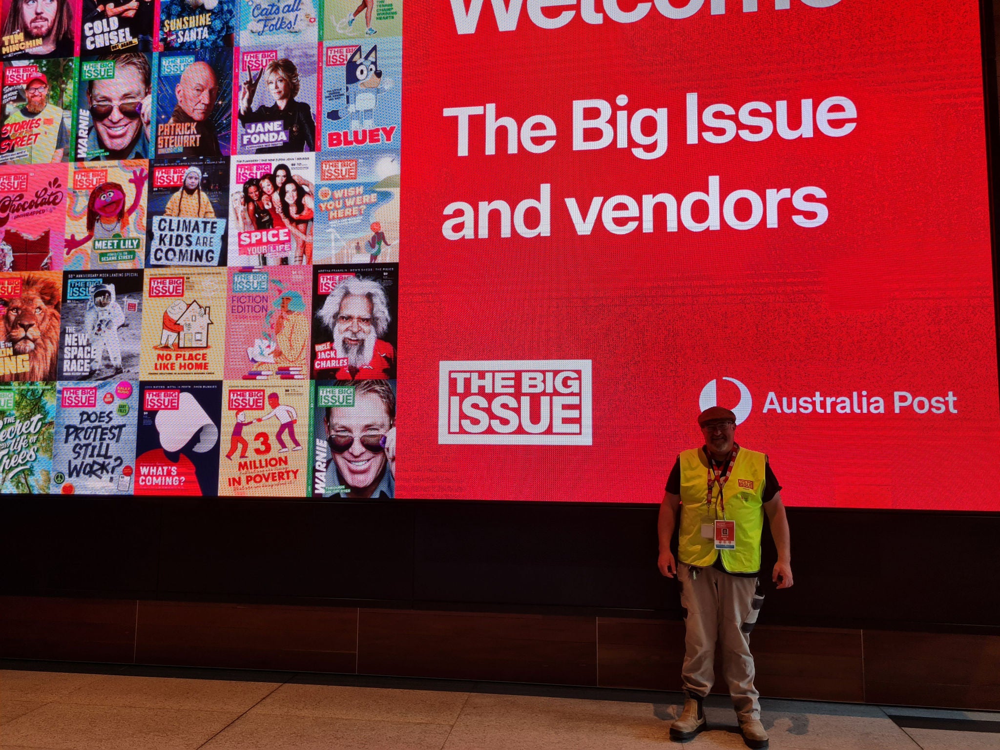 photo-the-big-issue-vendor-standing-in-front-of-big-screen