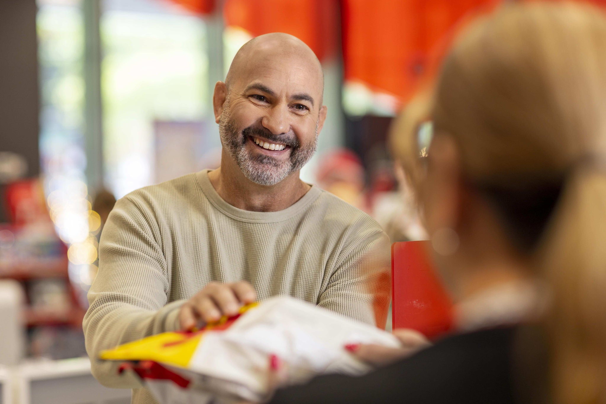 Photo of a male cutomer sending a parcel over the counter at a retail store