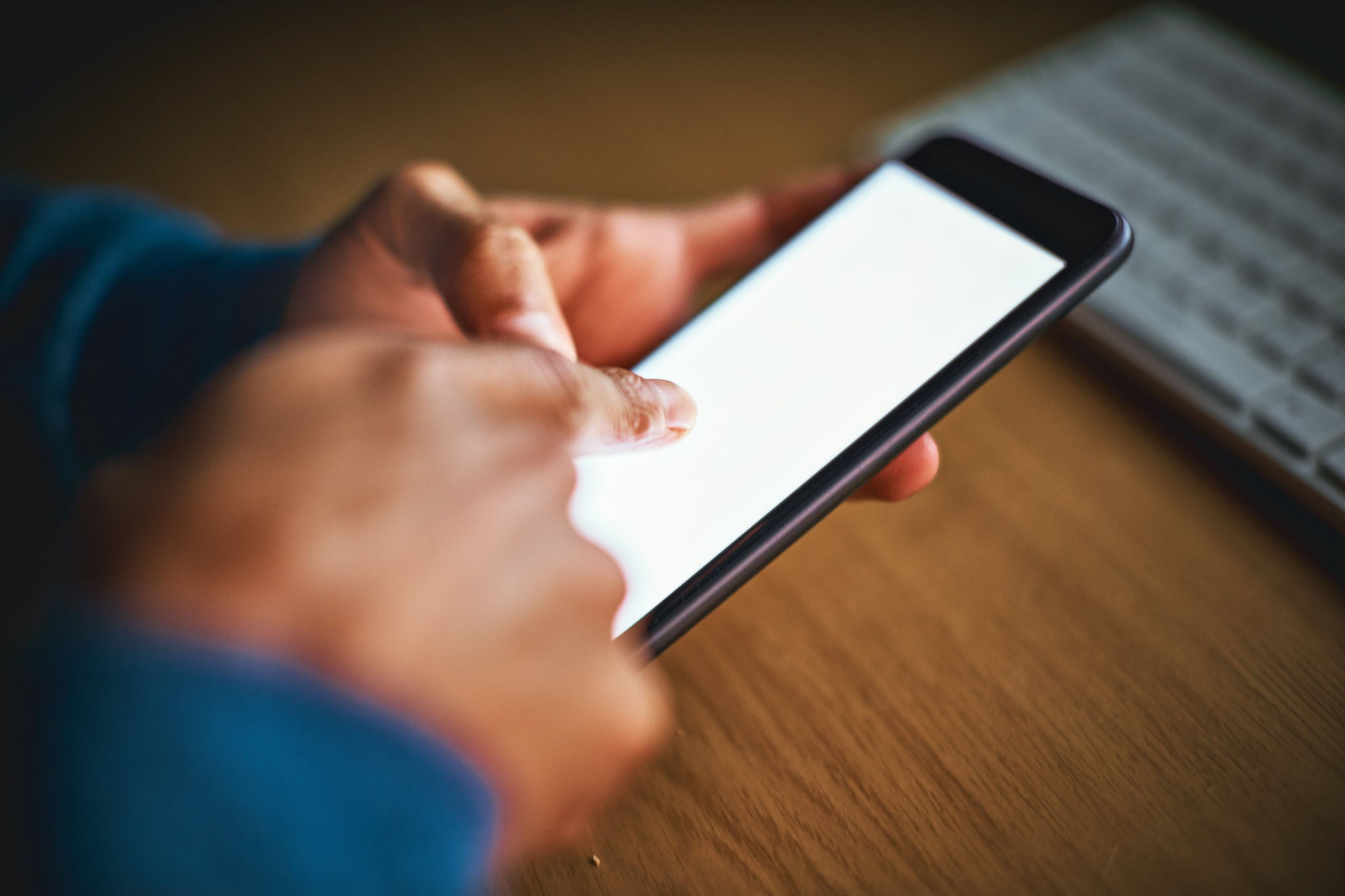 photo-a-man-tapping-the-blank-screen-of-a-mobile-phone
