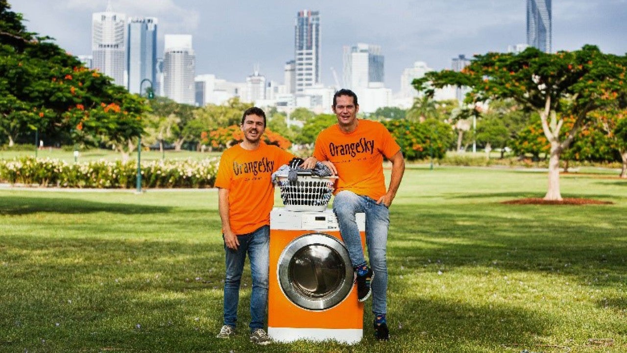 photo two men standing with washing machine in park