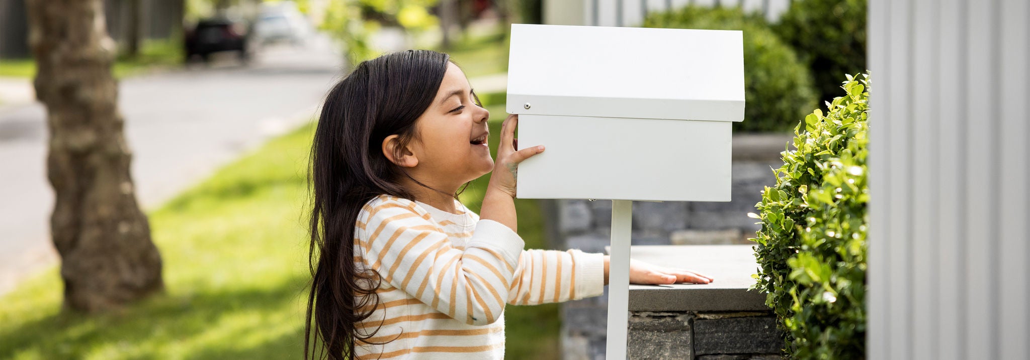 Photo of a young girl looking at a mailbox