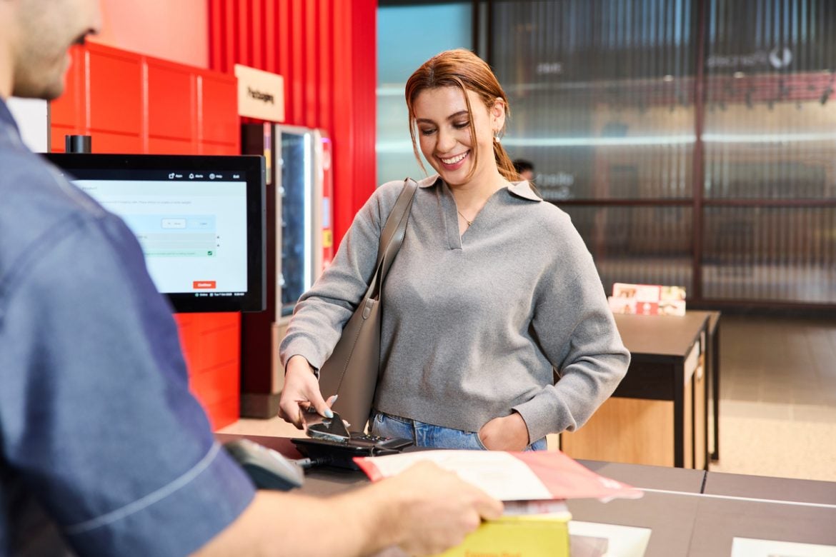 photo woman paying by phone at post office.