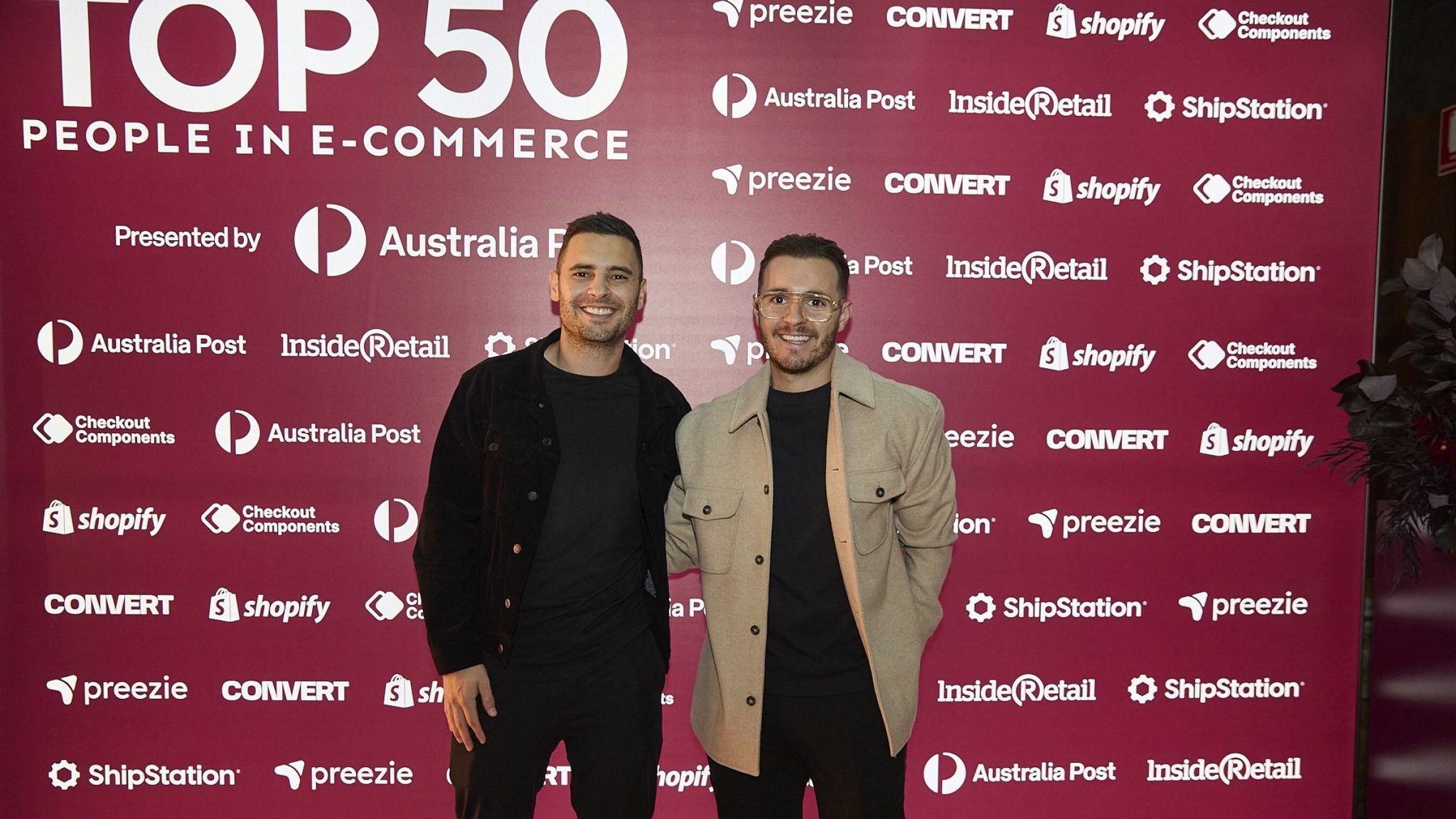 Two men at e-commerce awards backdrop