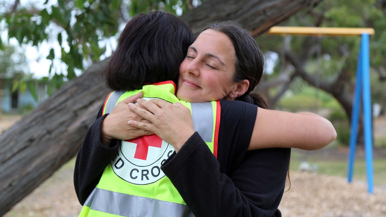 woman hugging red cross volunteer
