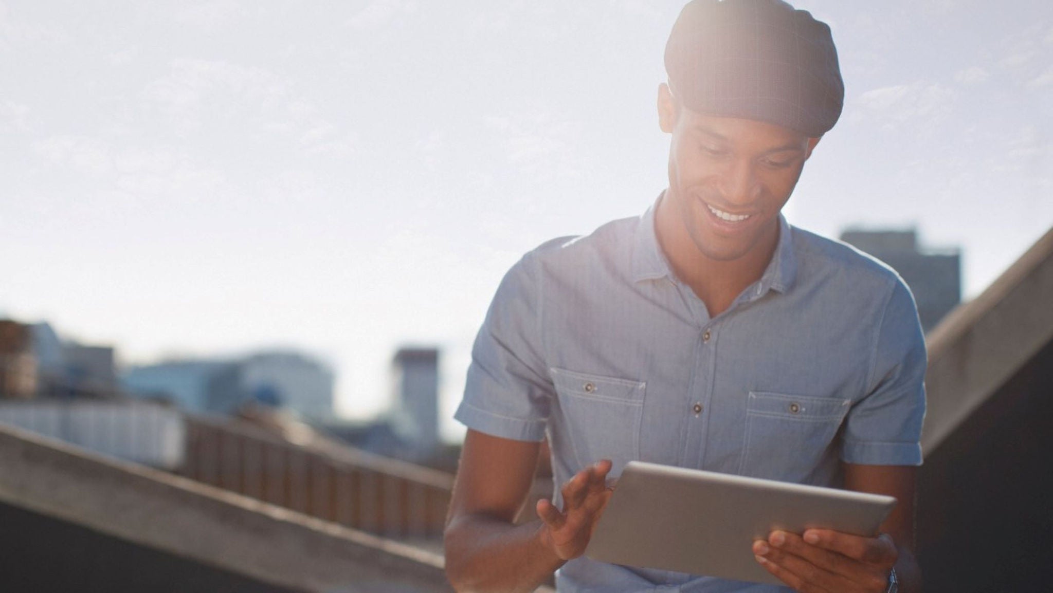 photo lifestyle young man outside tablet sunny day
