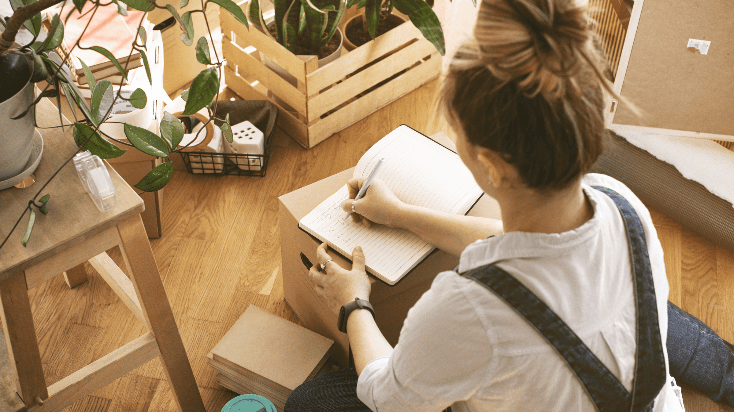 photo-woman-writing-list-moving-boxes-min